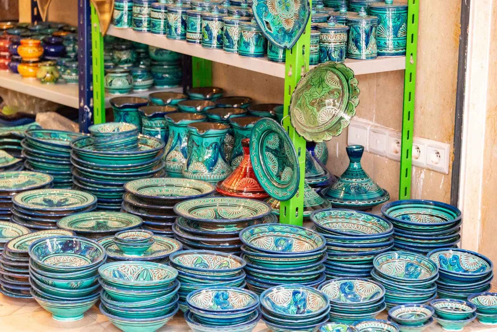 Colorful array of handcrafted pottery and ceramics in a shop setting, showcasing intricate patterns.